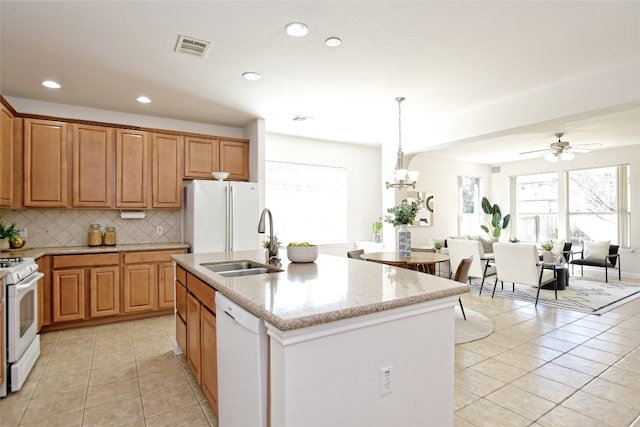 kitchen featuring white appliances, light tile patterned floors, visible vents, decorative backsplash, and a sink