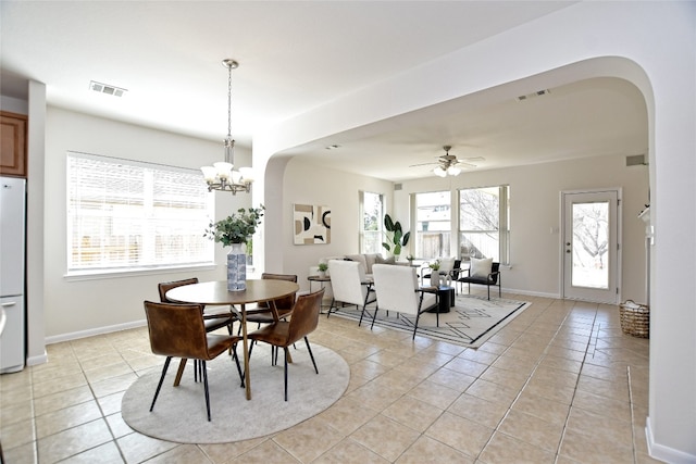 dining room with arched walkways, light tile patterned floors, and visible vents