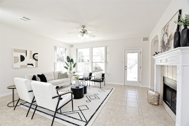 living area featuring light tile patterned flooring, a fireplace, a wealth of natural light, and baseboards