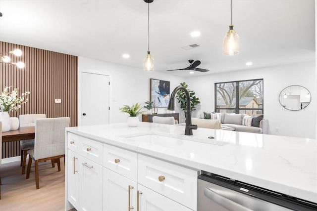 kitchen with decorative light fixtures, visible vents, white cabinetry, a sink, and dishwasher