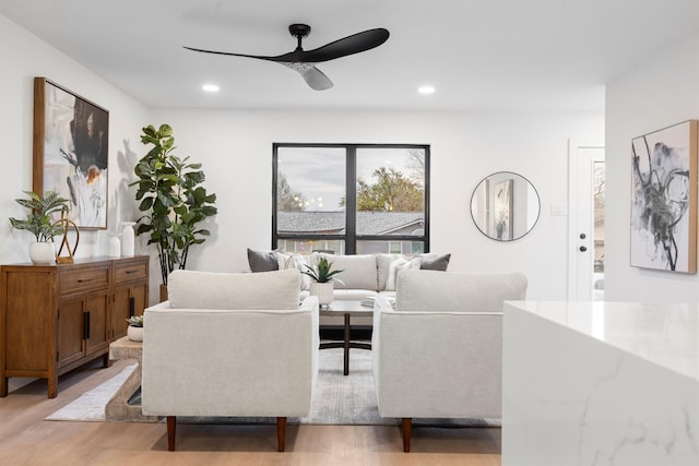 living area featuring light wood-style flooring, ceiling fan, and recessed lighting