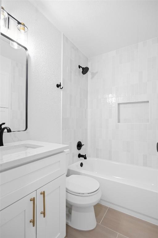 bathroom featuring toilet, shower / washtub combination, vanity, and tile patterned floors