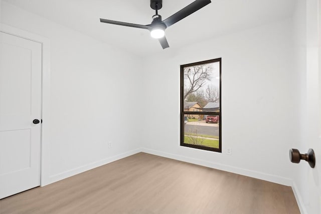 spare room with light wood-style floors, baseboards, and a ceiling fan