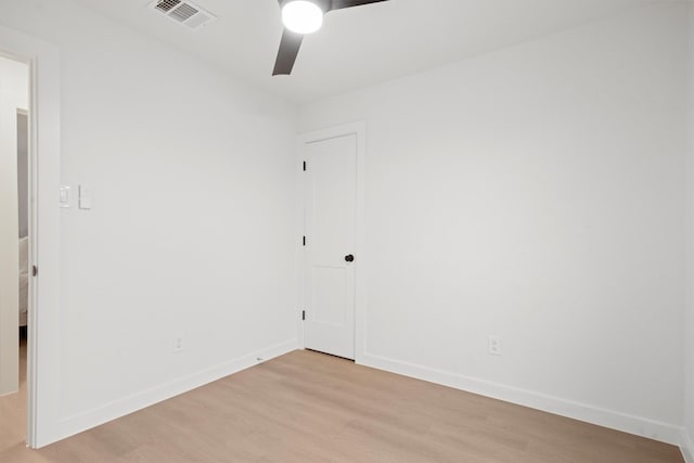 empty room featuring baseboards, light wood-type flooring, visible vents, and a ceiling fan