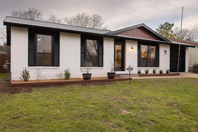 view of front of property with a front lawn and brick siding