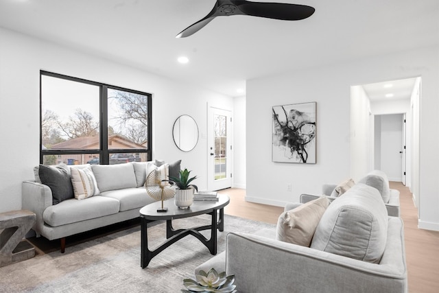 living area featuring light wood-style floors, a wealth of natural light, and baseboards