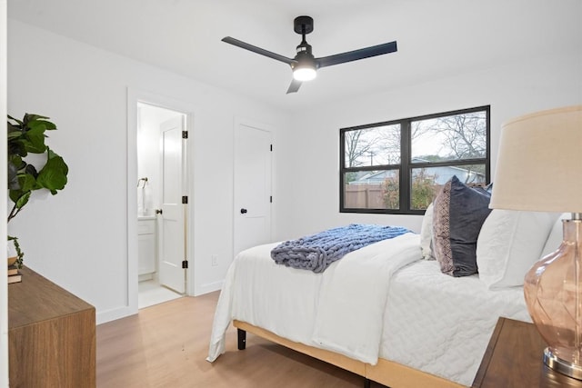 bedroom with a ceiling fan, baseboards, wood finished floors, and ensuite bathroom