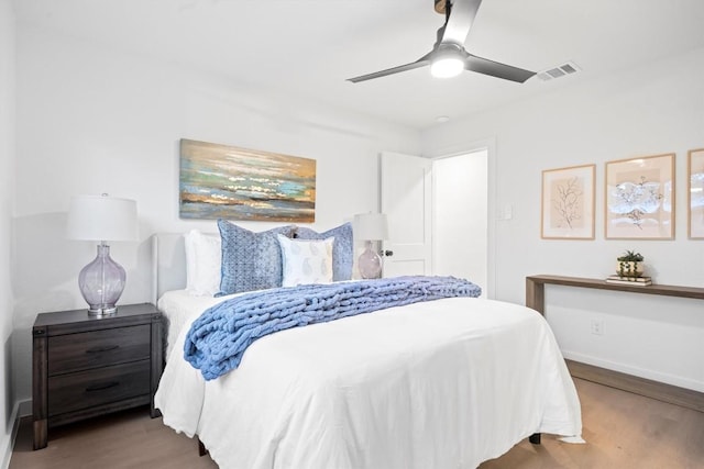 bedroom with visible vents, ceiling fan, baseboards, and wood finished floors