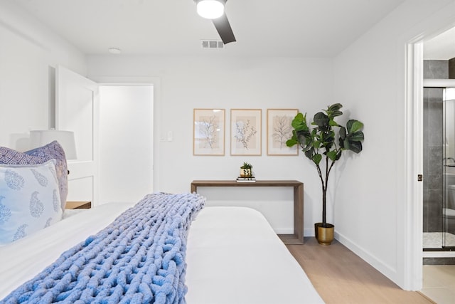 bedroom with ensuite bathroom, wood finished floors, a ceiling fan, visible vents, and baseboards