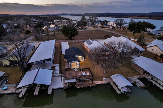 aerial view at dusk featuring a water view