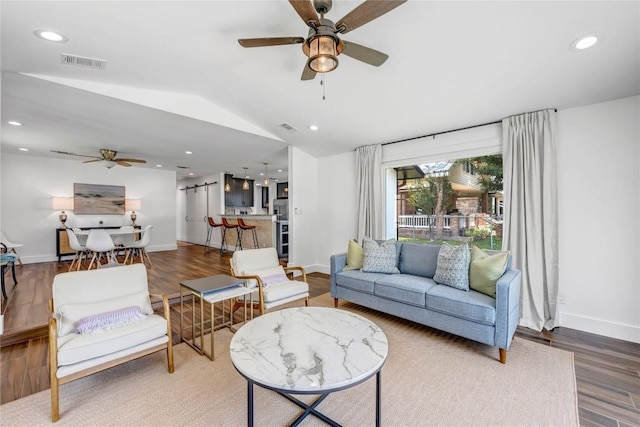 living area featuring visible vents, vaulted ceiling, wood finished floors, and recessed lighting