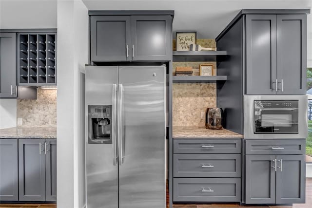 kitchen featuring open shelves, tasteful backsplash, gray cabinets, and stainless steel appliances