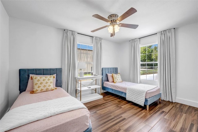 bedroom with ceiling fan, baseboards, and wood finished floors