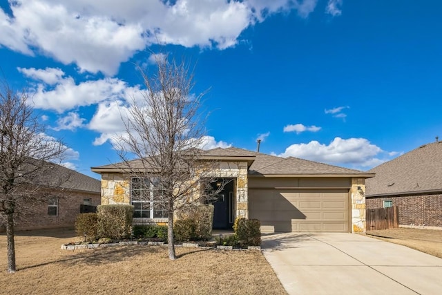 view of front of property with a garage, stone siding, fence, and driveway