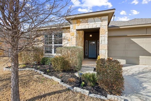 doorway to property with a garage, stone siding, a shingled roof, and driveway