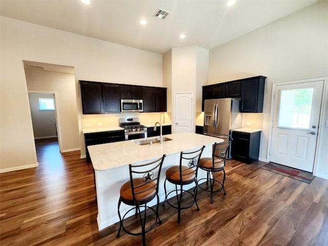 4337 Buffalo Ford Rd, Georgetown, TX 78628 - kitchen featuring appliances with stainless steel finishes, a sink, dark wood finished floors, a center island with sink, and a breakfast bar