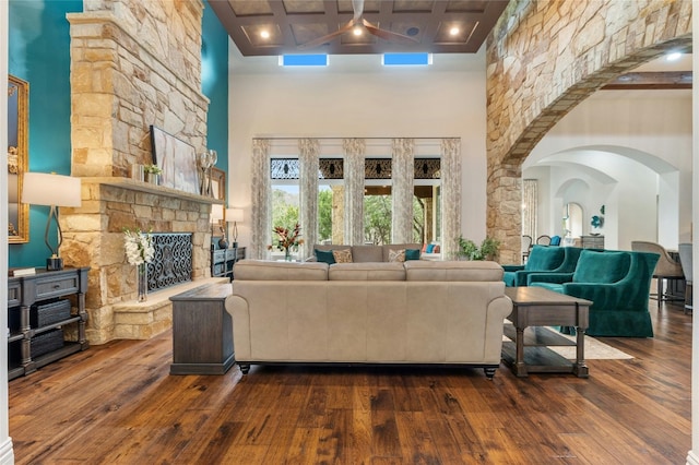 19520 Tessa Hts, Spicewood, TX 78669 - living area with hardwood / wood-style flooring, a towering ceiling, ceiling fan, a stone fireplace, and arched walkways