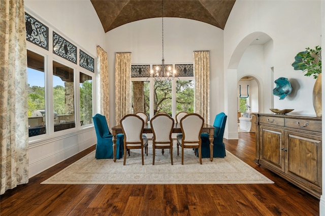 19520 Tessa Hts, Spicewood, TX 78669 - dining area with high vaulted ceiling, a chandelier, dark wood finished floors, baseboards, and arched walkways