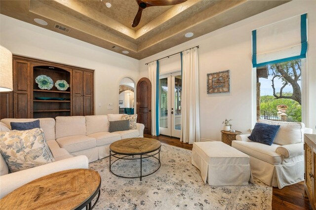19520 Tessa Hts, Spicewood, TX 78669 - living area featuring a raised ceiling, wood finished floors, french doors, a ceiling fan, and arched walkways