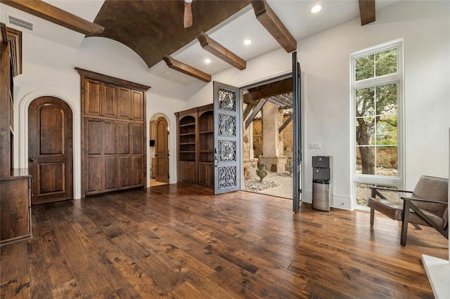 19520 Tessa Hts, Spicewood, TX 78669 - unfurnished living room featuring arched walkways, dark wood-style flooring, and baseboards