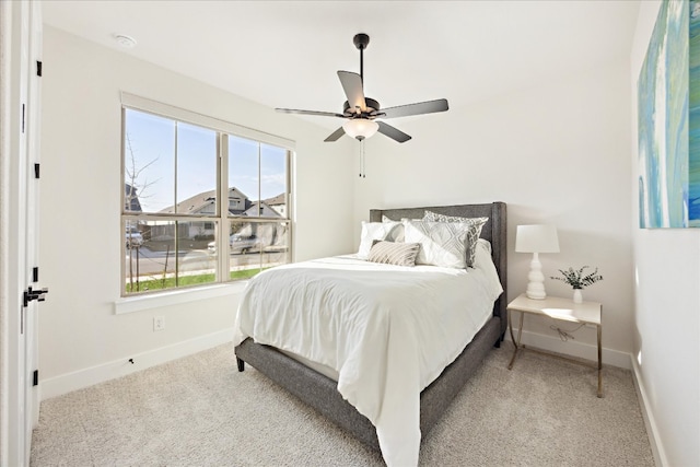 carpeted bedroom with baseboards and a ceiling fan