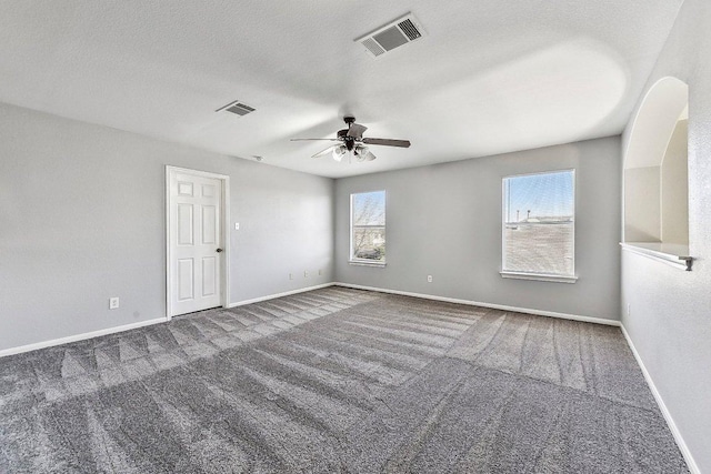 carpeted spare room with visible vents, ceiling fan, a textured ceiling, and baseboards