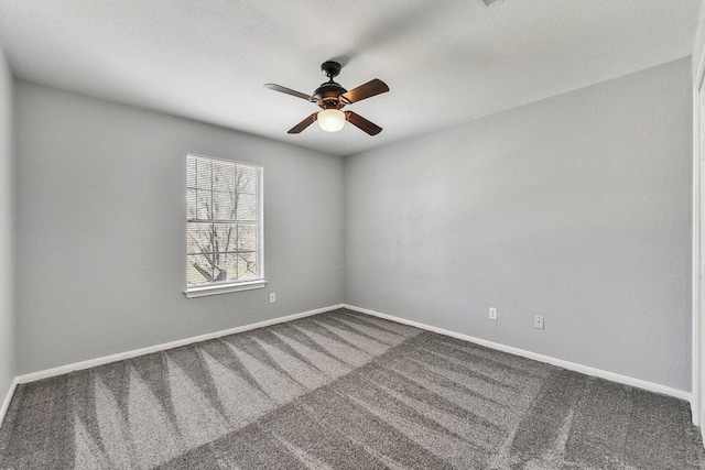 carpeted spare room with baseboards and a ceiling fan