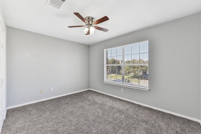 carpeted empty room featuring a ceiling fan, visible vents, and baseboards