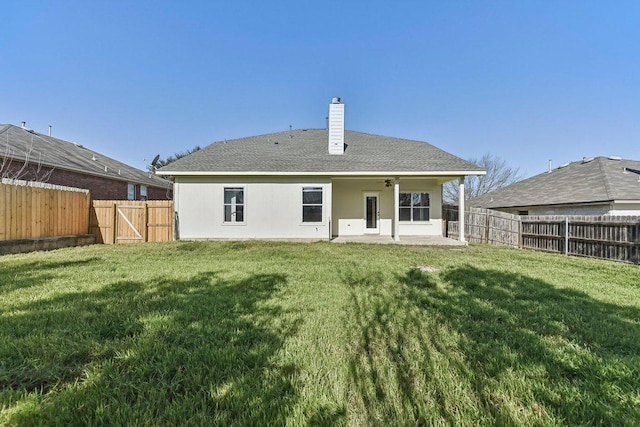 back of property with a fenced backyard, a lawn, stucco siding, a chimney, and a patio area