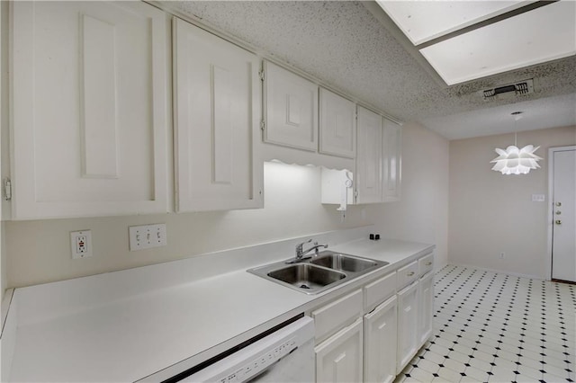 kitchen with a sink, visible vents, white cabinetry, light countertops, and light floors