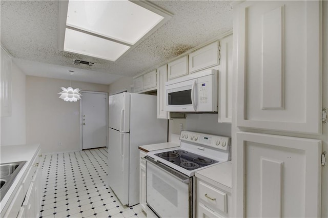 kitchen with white appliances, white cabinets, light countertops, light floors, and a sink