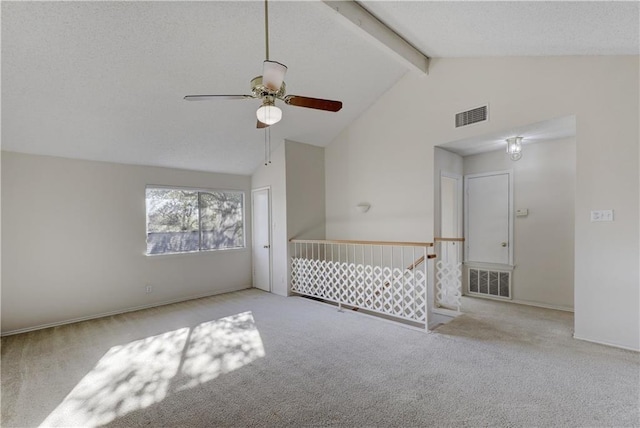 carpeted spare room with high vaulted ceiling, a ceiling fan, visible vents, and beam ceiling