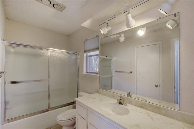 bathroom featuring toilet, shower / bath combination with glass door, and vanity