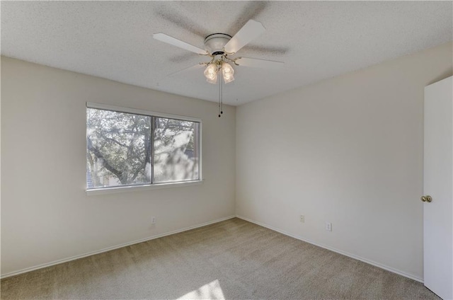 carpeted spare room with a ceiling fan, a textured ceiling, and baseboards