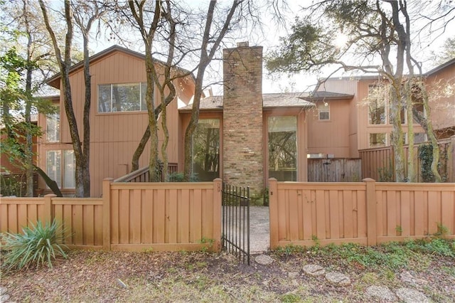 view of front of home featuring a fenced front yard and a chimney