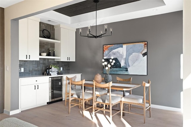 dining room featuring beverage cooler, visible vents, baseboards, light wood-style flooring, and a notable chandelier