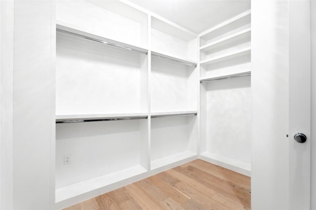 walk in closet with wood finished floors