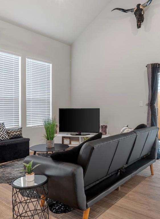 living area featuring vaulted ceiling and wood finished floors