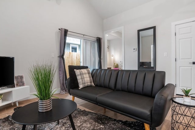 living area featuring vaulted ceiling and light wood-style flooring