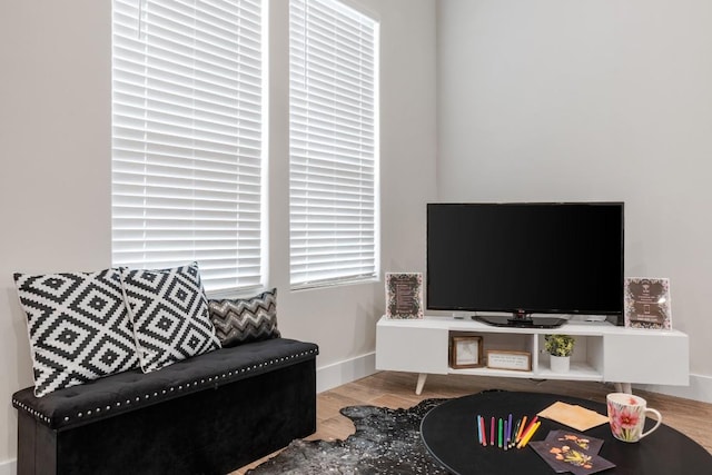 living area with baseboards and wood finished floors