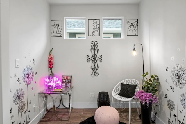 living area with baseboards and wood finished floors