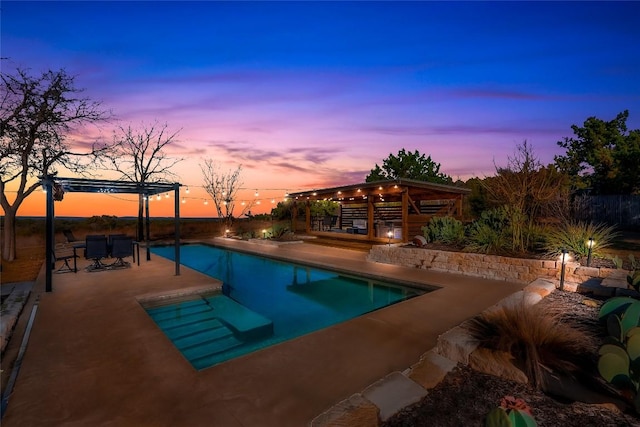 pool at dusk with a patio area and an outdoor pool