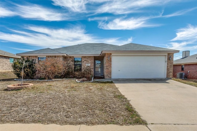 ranch-style home featuring a garage, central AC, concrete driveway, and brick siding