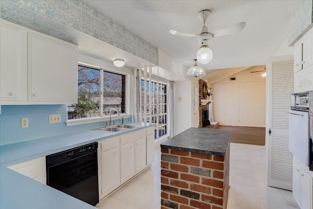 kitchen with black dishwasher, ceiling fan, a textured ceiling, white cabinetry, and a sink