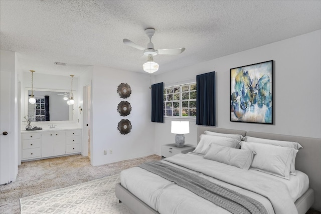 bedroom with light carpet, visible vents, ensuite bath, ceiling fan, and a textured ceiling