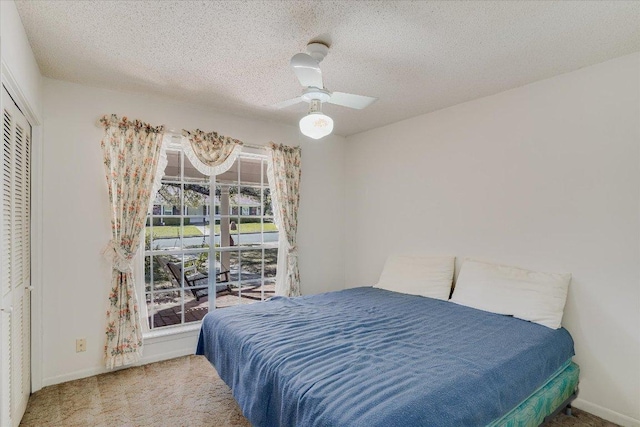 bedroom featuring a textured ceiling, carpet floors, a ceiling fan, baseboards, and a closet