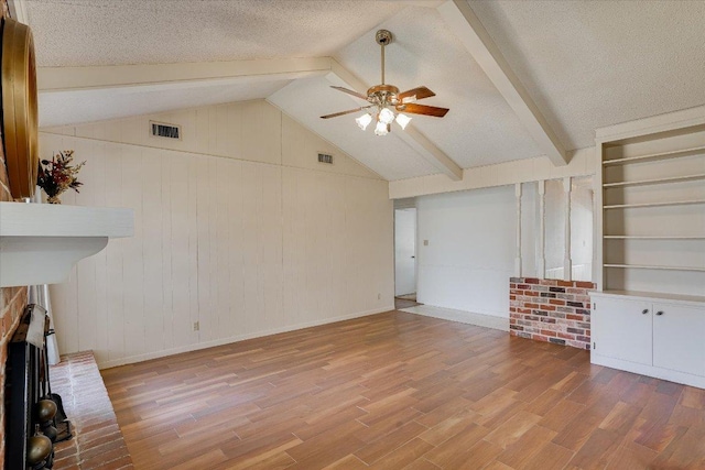 unfurnished living room with a ceiling fan, visible vents, a textured ceiling, and wood finished floors