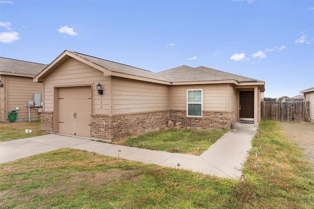 view of front facade featuring an attached garage, a front yard, fence, and brick siding