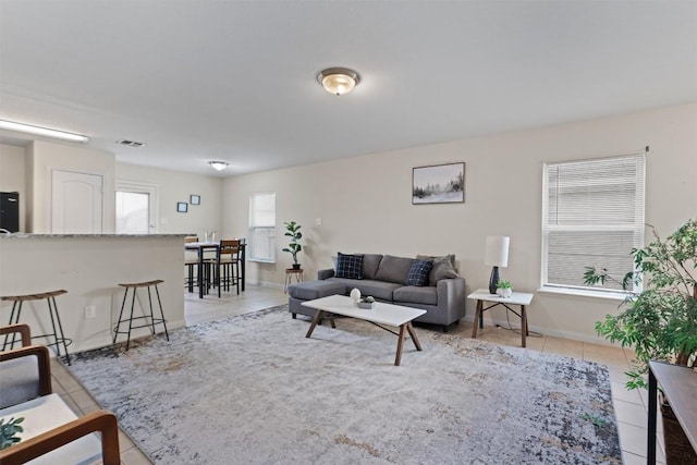 living room with visible vents, baseboards, and light tile patterned floors