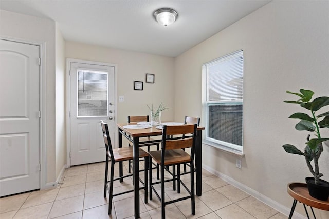 dining area featuring light tile patterned floors and baseboards